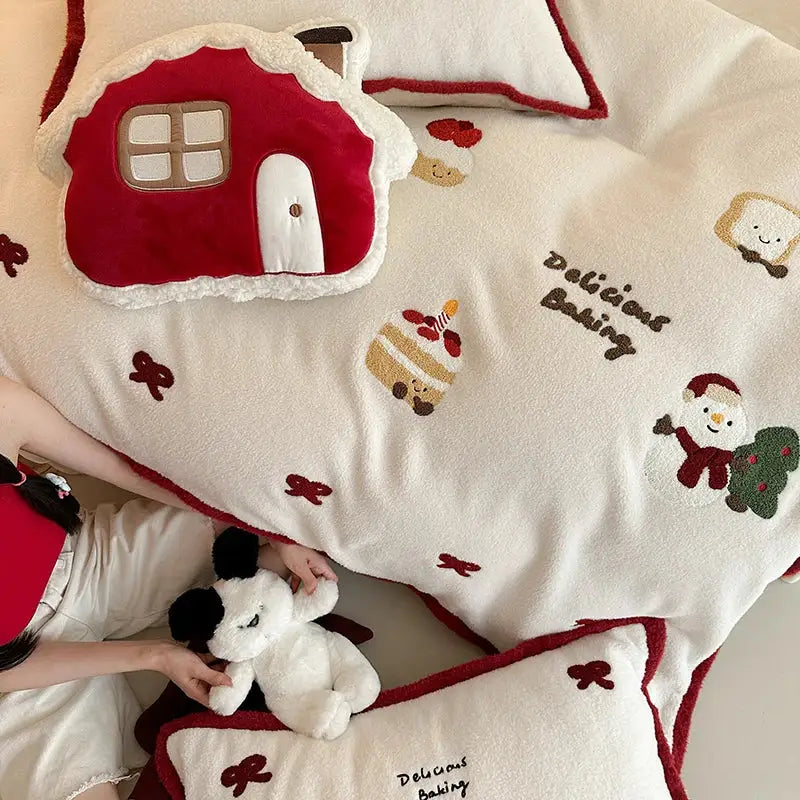 Cream-colored plush bedding set featuring red and white cartoon embroidered holiday designs by decorbites