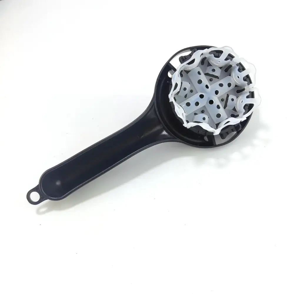 Black plastic hand-held juicer with white cross-shaped grinding mechanism suitable for espresso machine cleaning brush tasks