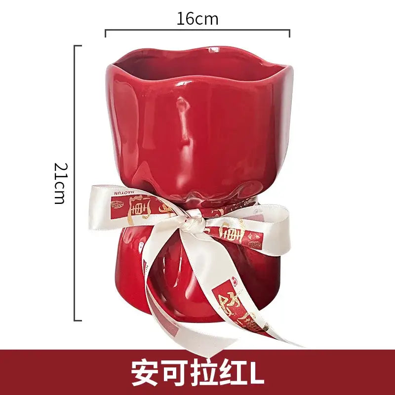 A glossy red bouquet shape ceramic planter with a wavy rim and a white ribbon with gold chinese characters for decorbites bouquet shape decor