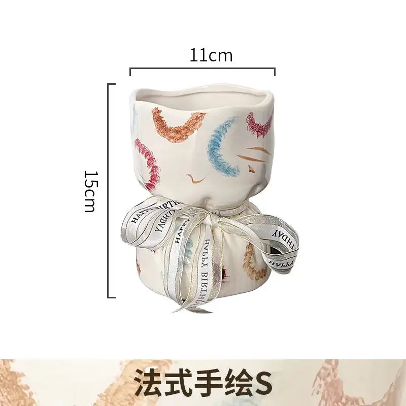 A white ceramic cat planter with hand-painted pink blue and gold whiskers ideal as bouquet shape ceramic decorbites bouquet shape decor