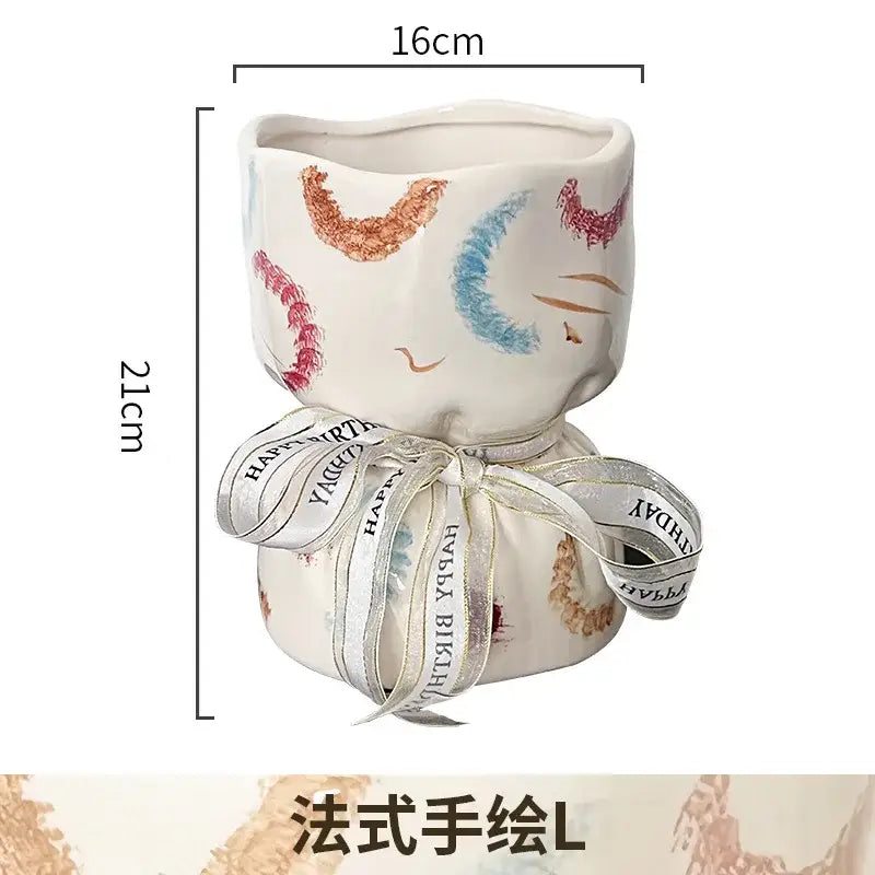 A white ceramic bouquet shape planter with hand-painted pink blue and copper cat face decorbites bouquet shape decor