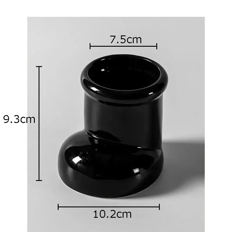 Black glossy ceramic vase with flared rim and rounded base shown as part of red ceramic boot desk organizer box for office use
