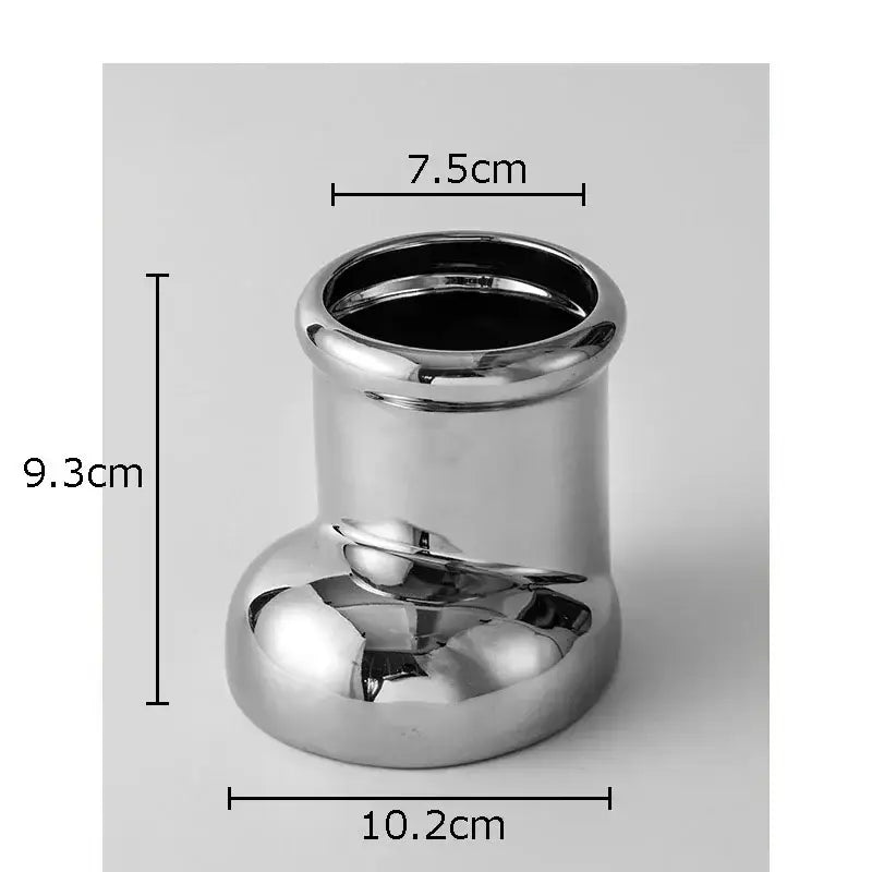 Shiny silver metallic cylindrical vase with a rounded base as a reflective desk organizer box for office storage