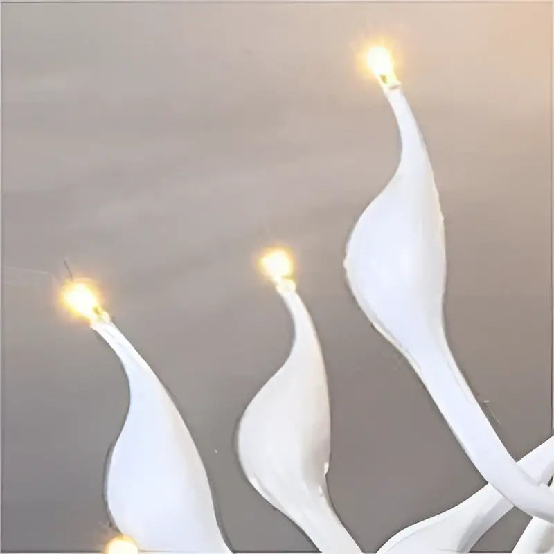 White slender flame-shaped candle holders with glowing tips in a red glass iron swan pendant lamp chandelier