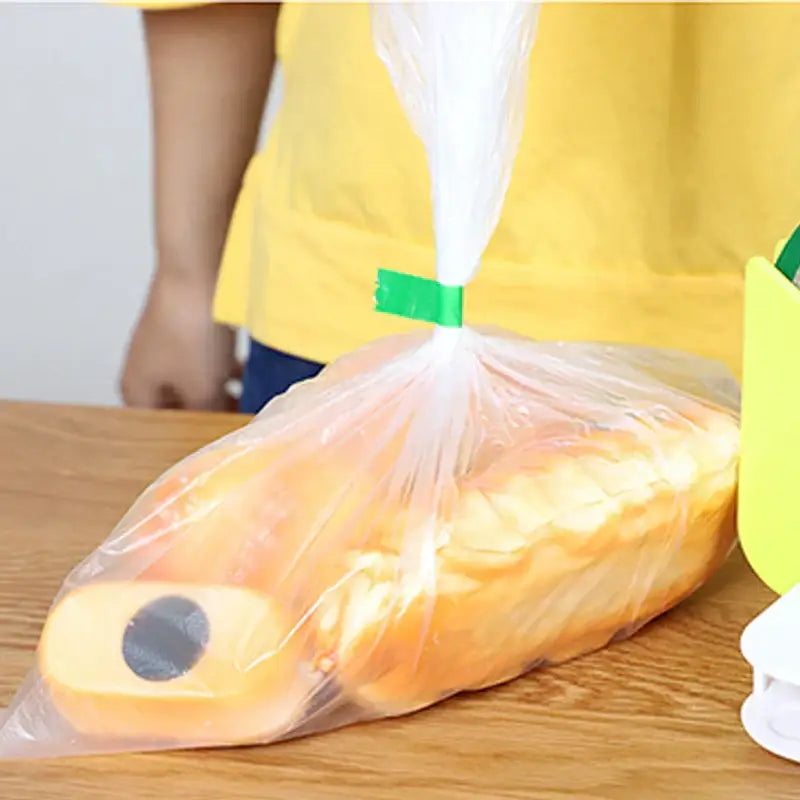 Clear plastic bag with green bag seal tape securing rolled-up orange paper towels for kitchen freshness sealing rolls