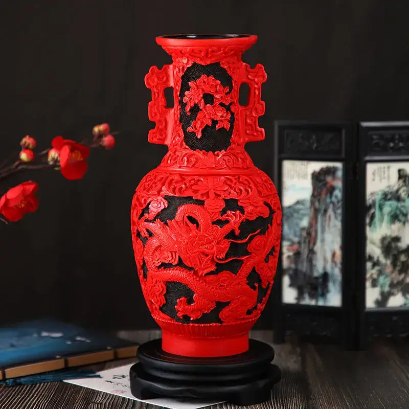 A vibrant red lacquerware flower auspicious vase with intricate dragon carving and ornate handles on a dark wooden base