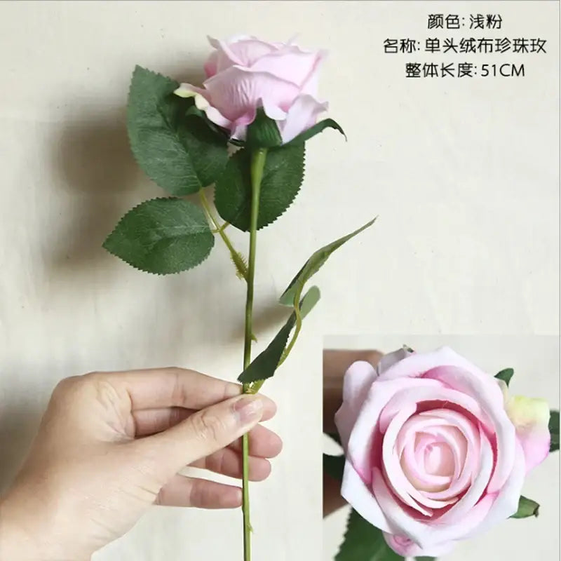 A delicate light pink fabric rose with layered petals and green leaves from decorbites dried roses artificial wedding decor