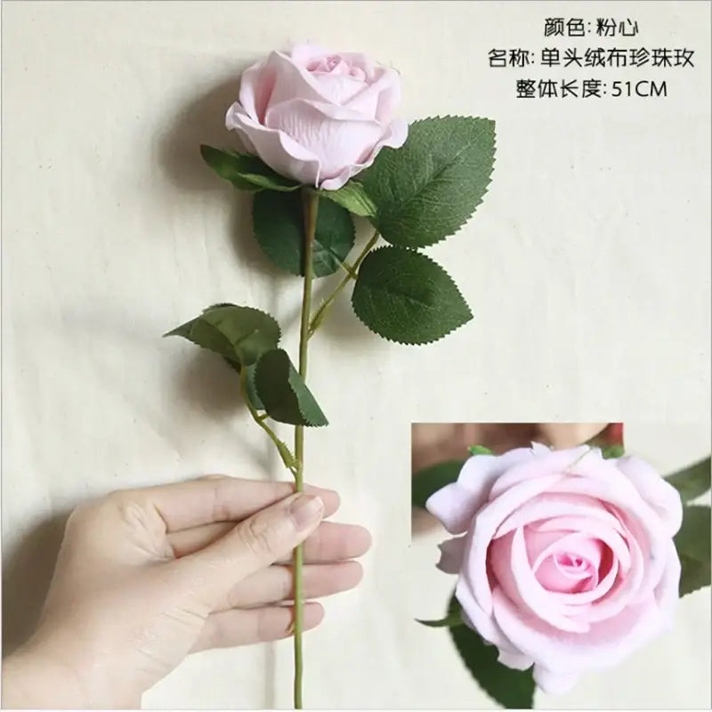A delicate pink artificial rose with soft layered petals and green fabric leaves from decorbites dried roses wedding decor