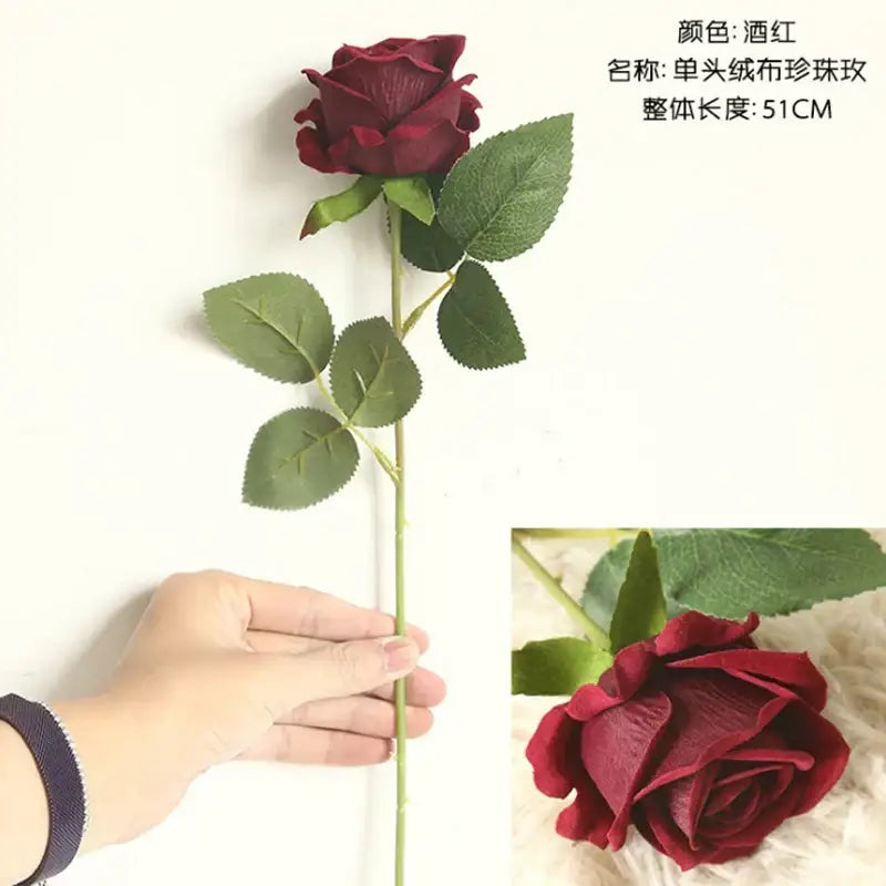 A deep wine-red decorbites dried roses artificial flower with glossy layered petals and green leaves on a slender stem