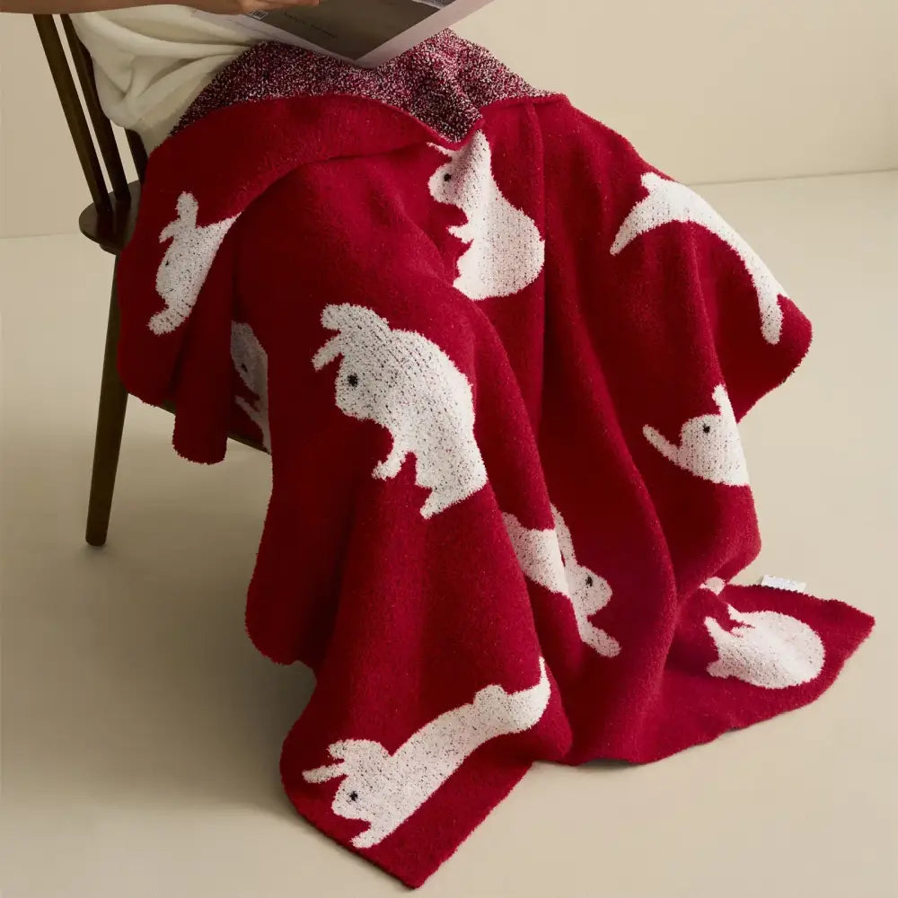 Red regina lively rabbit throw blanket featuring a plush red fabric with white textured bunny silhouettes decorbites lively