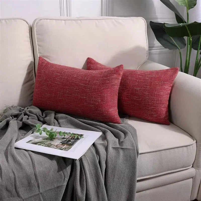 Two red textured linen throw pillow covers resting on a beige sofa for decorbites linen throw pillow decor