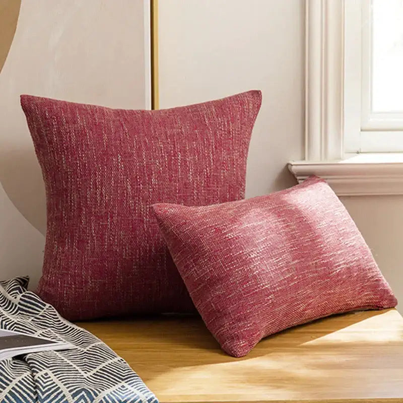 Two red textured linen throw pillow covers with woven pattern rest on wooden surface for living room decorbites decor
