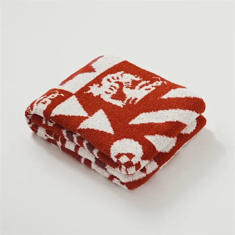 A plush terracotta-red and white decorbites knitted blanket throw with geometric and dragon zodiac patterns for bedroom decor
