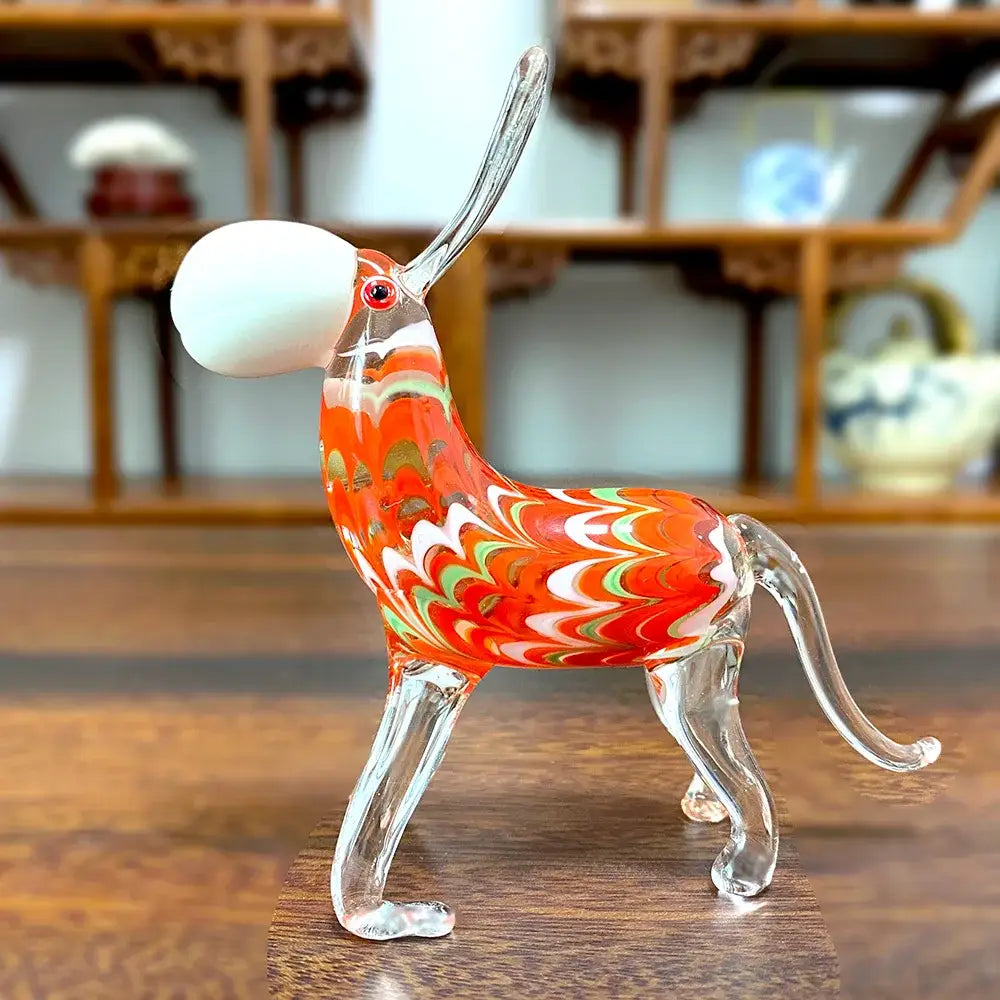 A vibrant orange white and green swirl glass donkey figurine with clear legs and silver horn for living room decor