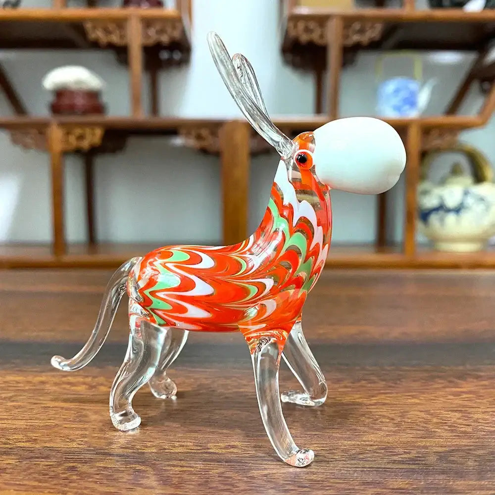 A vibrant glass donkey figurine with swirling orange and green patterns clear legs and a white headpiece for decor