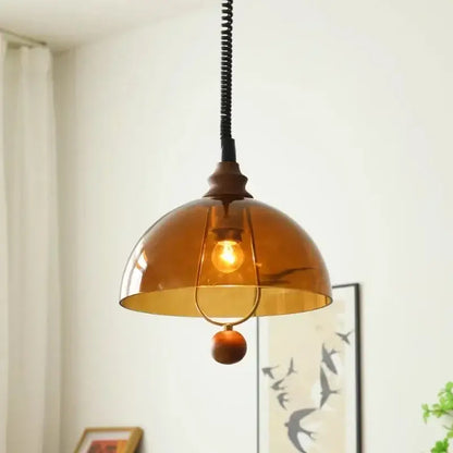 Warm amber glass pendant light with brass frame and wooden bead accent for dining room decorbites amber shades retro