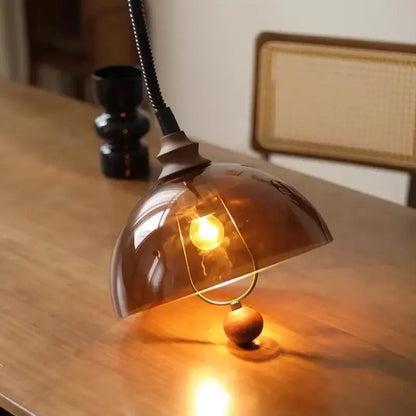 Warm amber glass dome pendant light with brass base and black gooseneck for retro amber shades decorbites style