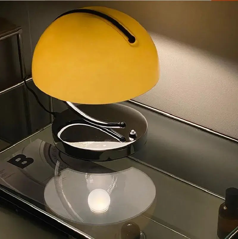 A sleek decorbites glass table lamp with a vibrant yellow dome shade and black base with chrome accents for bedroom decor
