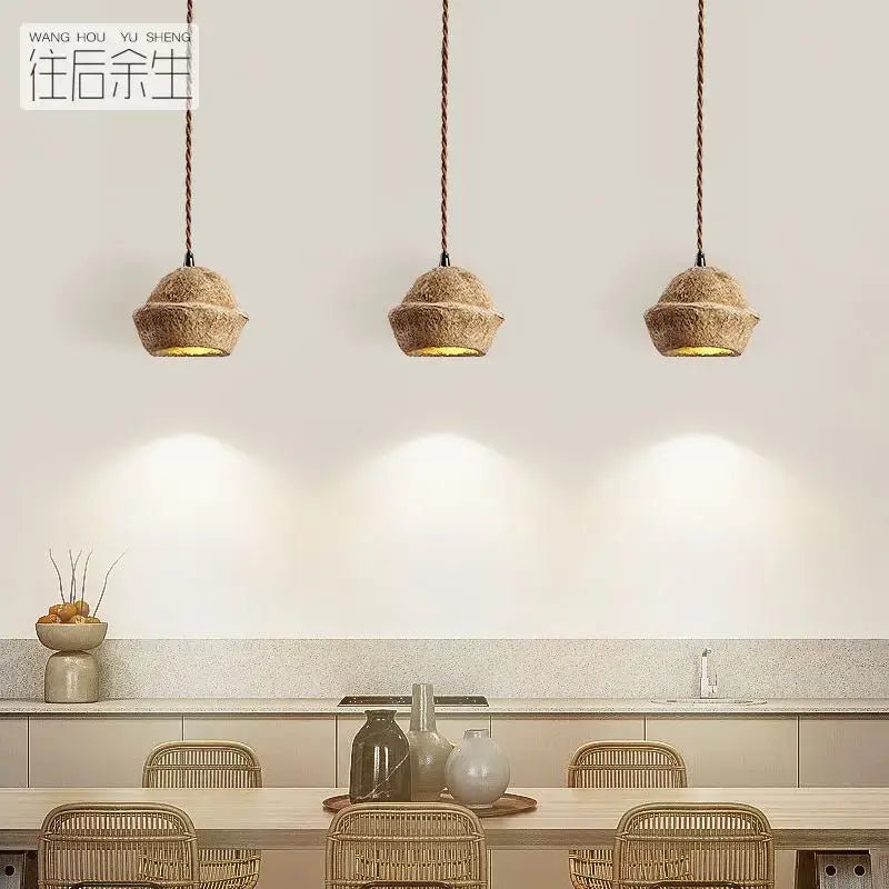 Retro beige cork fruit shell bedside pendant light with three rustic woven beige pendant lights hanging above table