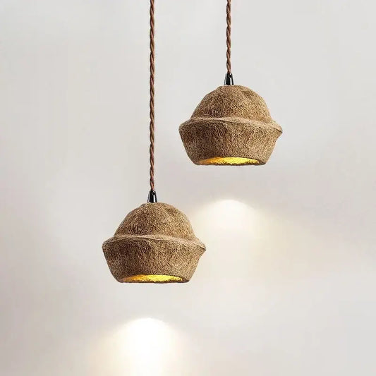 Two rustic beige cork pendant lights with twisted brown cords and warm golden interiors for fruit shell bedside decorbites