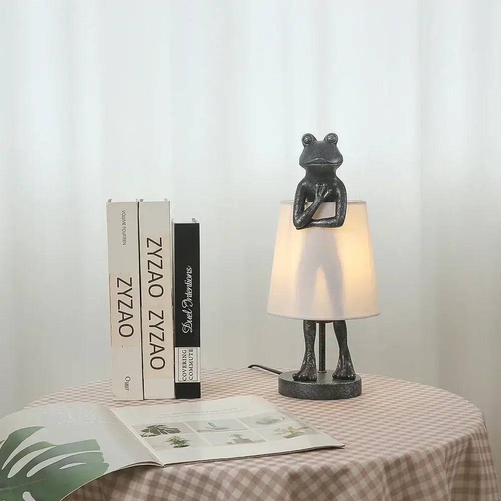 Dark gray resin frog resin desk lamp with white fabric shade for retro bedroom lighting by decorbites frog resin