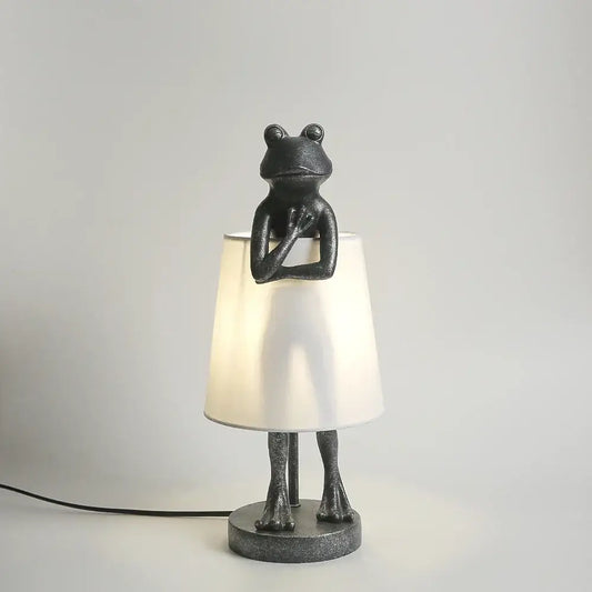 Black frog resin desk lamp with matte finish, articulated limbs and white conical shade for bedroom lighting decorbites frog resin