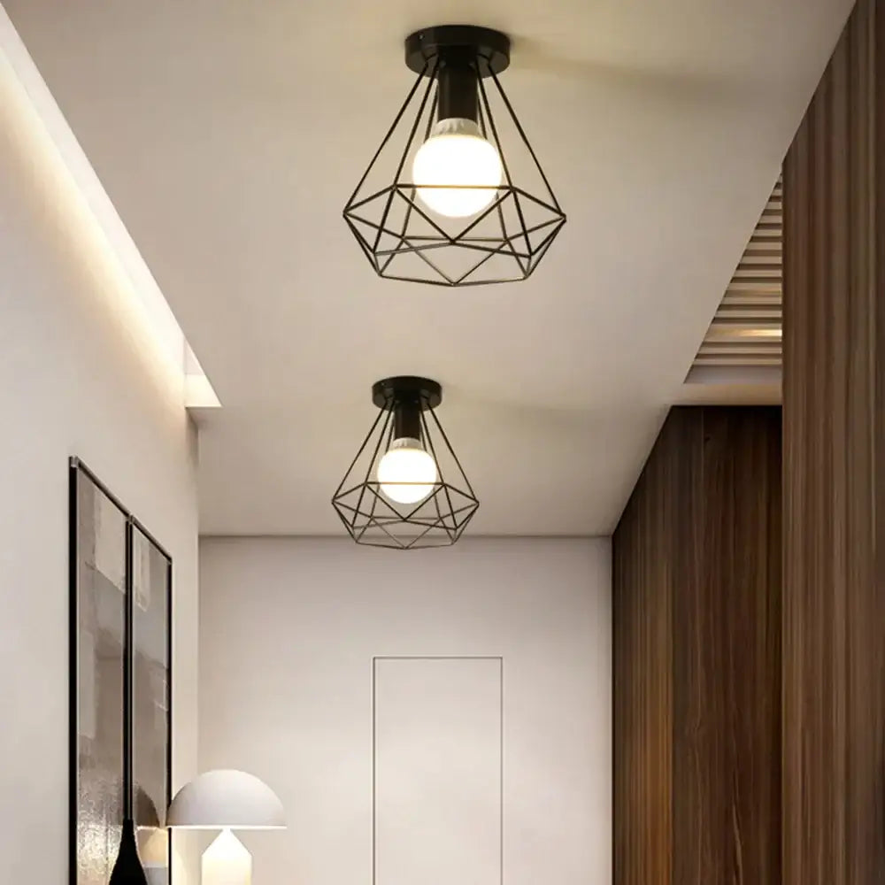 Black geometric wireframe ceiling lamp with warm glowing bulb made of decorbites iron black for living room decor