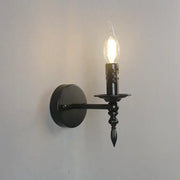 Retro black iron art wall lamp featuring a black wrought iron candlestick-style sconce with a glowing filament bulb