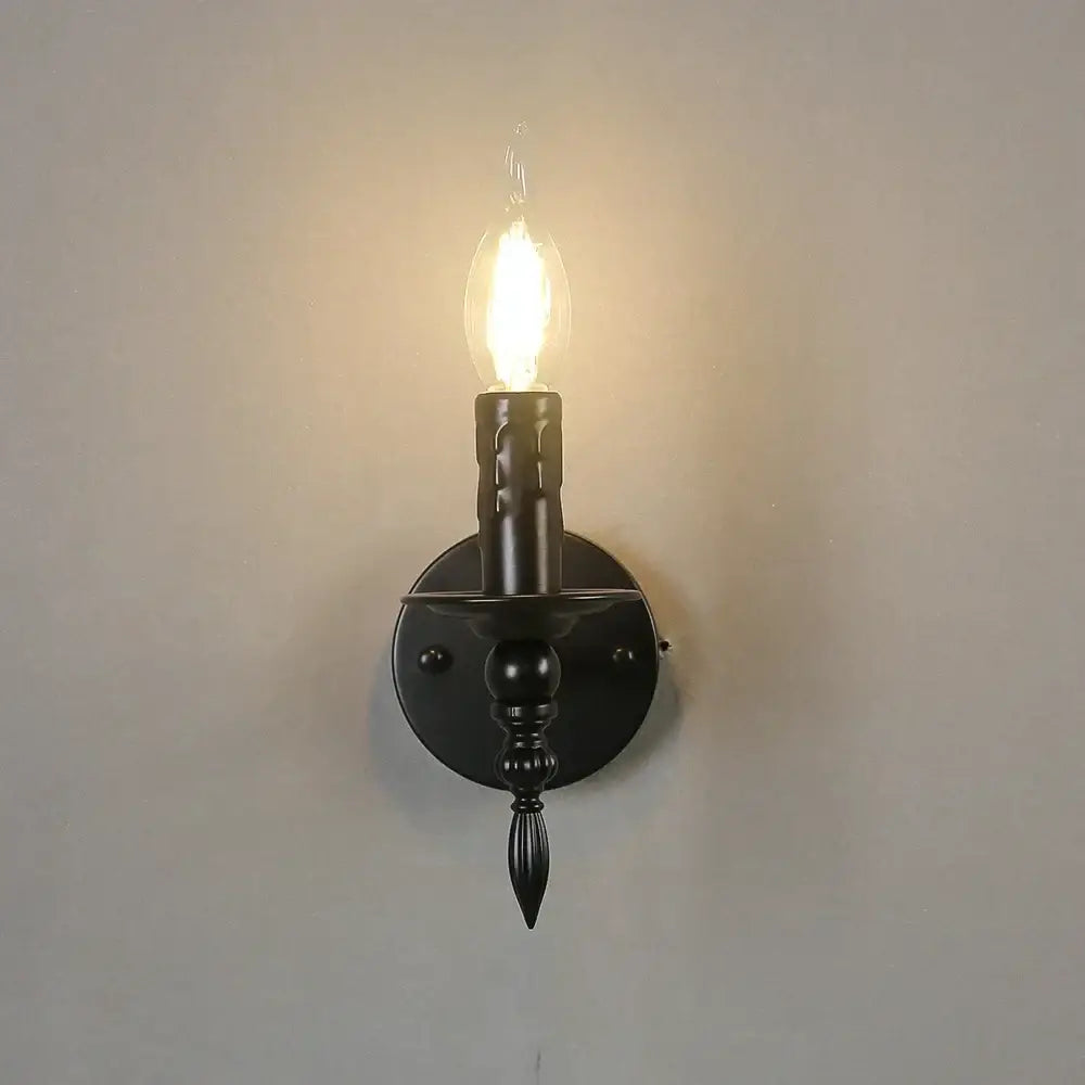 Retro black iron art wall lamp with candle-style wrought iron sconce and glowing filament bulb for living room decorbites iron art wall