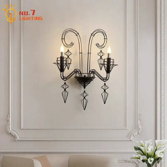 Retro black wrought iron wall lamp with ornate scrollwork and three candle-style bulbs for living room use