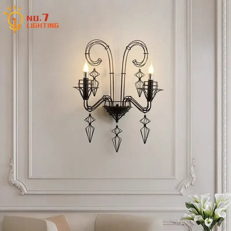 Retro black wrought iron wall lamp with ornate scrollwork and three candle-style bulbs for living room use