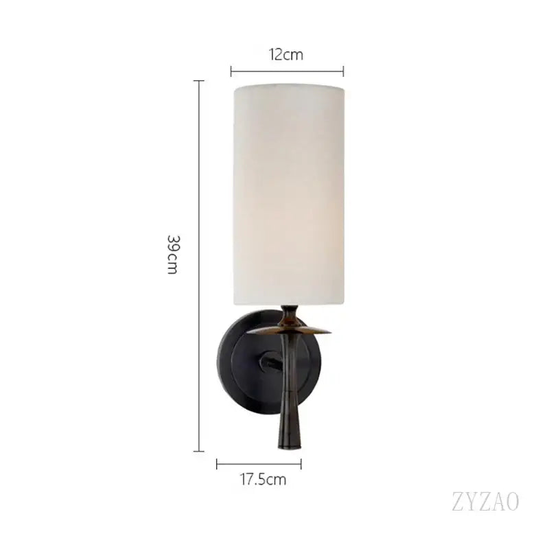 A sleek black metal brass wall lamp with a cylindrical off-white fabric shade and slender stem for bedroom decorbites brass wall lamp