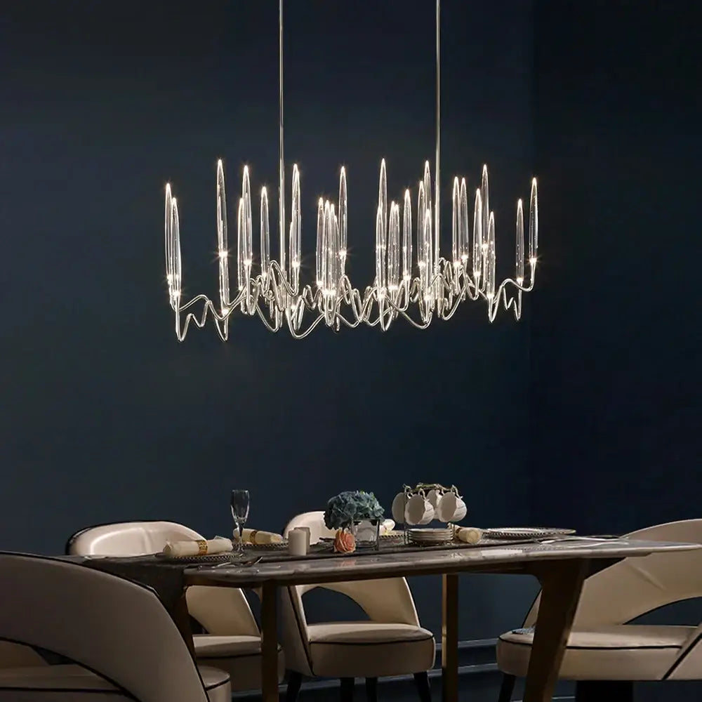 Modern crystal chandelier with slender glass arms and metallic frame complements retro black rattan chair puma cushion decorbites crystal candle