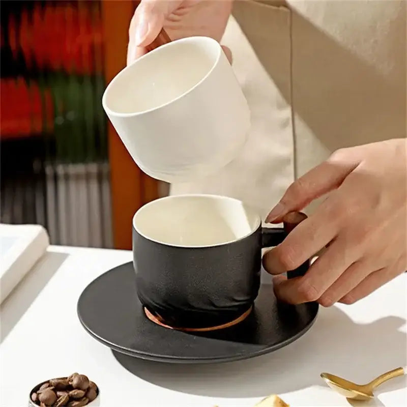 Black ceramic coffee cup with matte finish, gold rim, on matching saucer from decorbites 130ml blue kitchen set with wooden handle