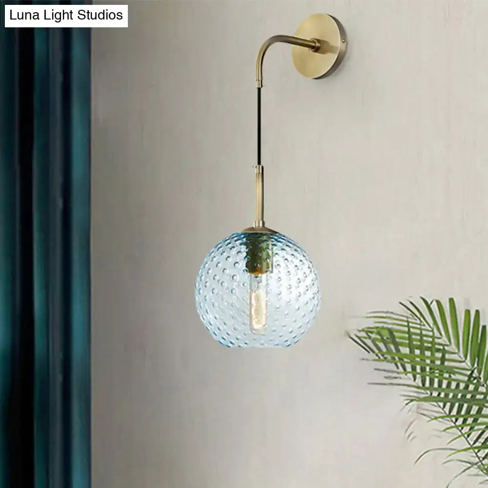 Retro blue glass globe wall lamp with textured bubble surface and brass hardware for pink yellow blue lighting