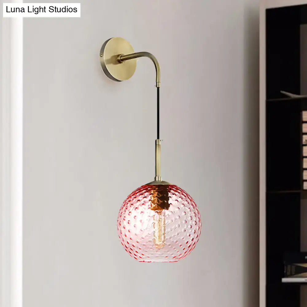 Delicate pink glass globe pendant light with textured bubble surface and brass hardware for pink yellow blue decor