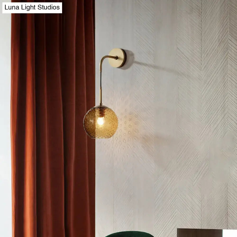Gold-toned wall sconce with textured amber glass globe for pink yellow blue retro bedroom lighting decor