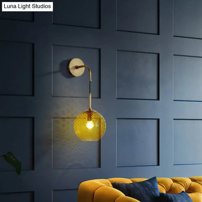 Gold-toned wall sconce with textured amber glass globe for pink yellow blue retro bedroom lighting decor