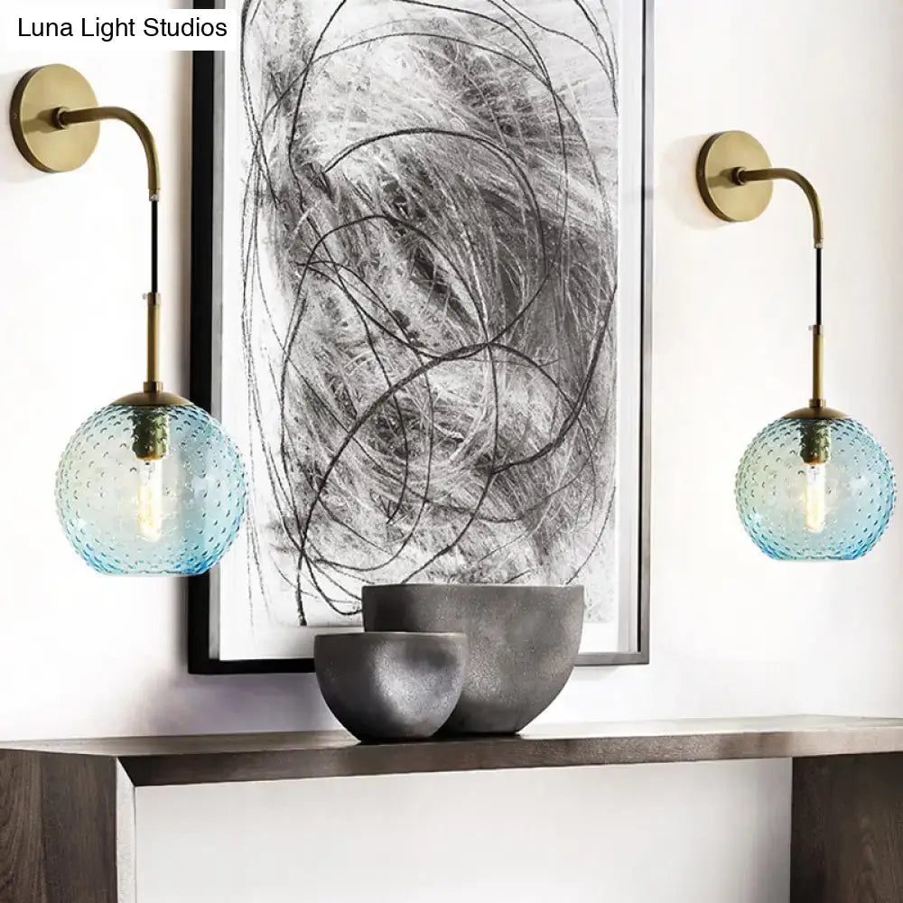Retro blue glass globe wall lamp with brass fixtures featuring textured blue glass for pink yellow blue lighting ambiance
