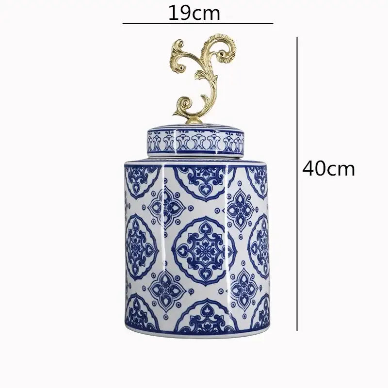 A tall retro vase jar with intricate blue and white geometric patterns and a gold porcelain covered lid handle