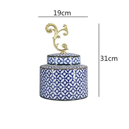 A blue and white patterned porcelain covered vase jar with a gold-toned ornate lid for living room storage