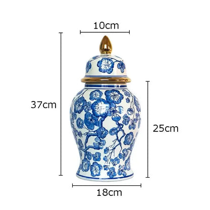 A tall elegant porcelain ginger jar with white base blue floral patterns and gold tipped lid for decorbites blue collection