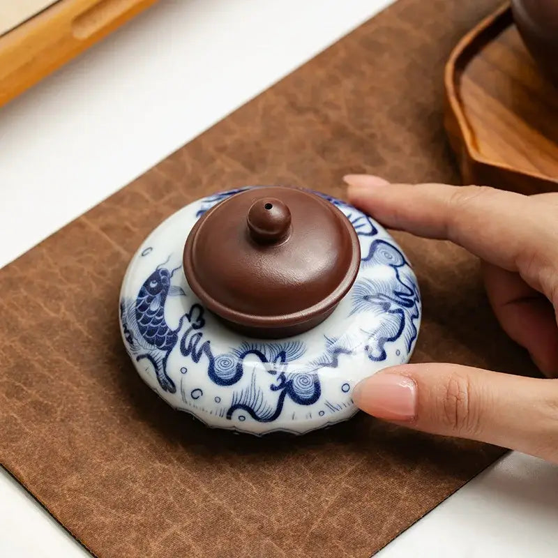 Traditional chinese-style ceramic tea caddy with blue dragon and fish motifs on a glossy white body for teacup tray set