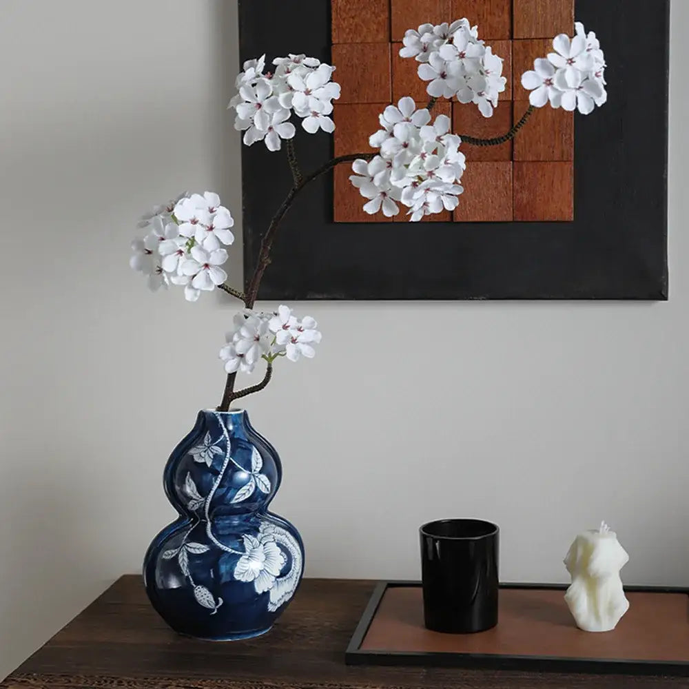 Deep blue white porcelain vase with floral vine patterns holding artificial white blossoms for living room decorbites blue white