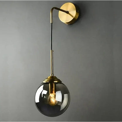 Brass finished wall lamp with sleek curved arm and dark smoked decorbites glass ball led globe for bathroom sconce
