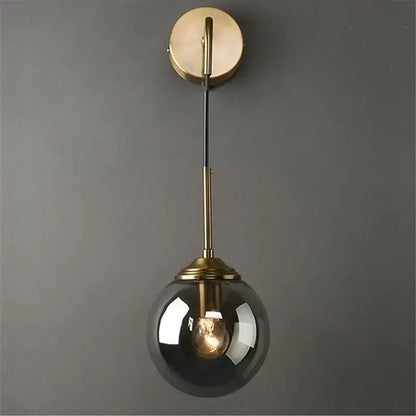 A sleek retro brass wall lamp with a decorbites glass ball led and smoked glass globe bathroom sconce