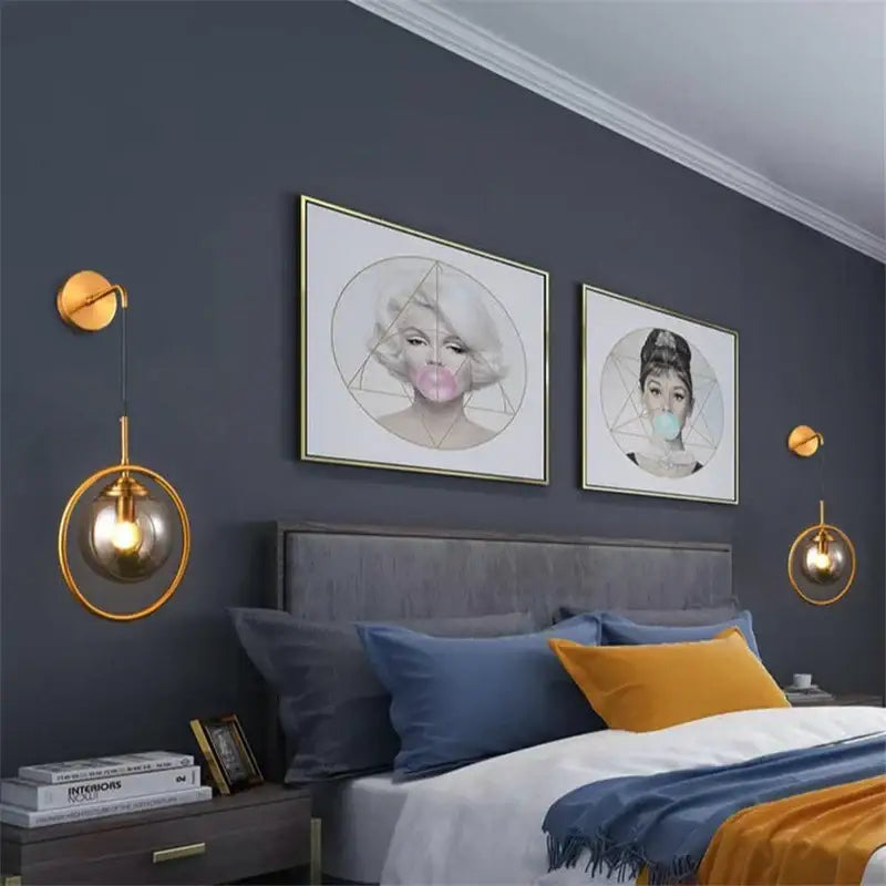 Gold-toned retro brass and amber decorbites glass ball wall lamp with glass ball led shades hangs symmetrically by bed