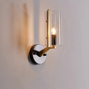 Retro brass and black wall light featuring a brass-finished transparent glass sconce with a clear cylindrical shade and exposed bulb