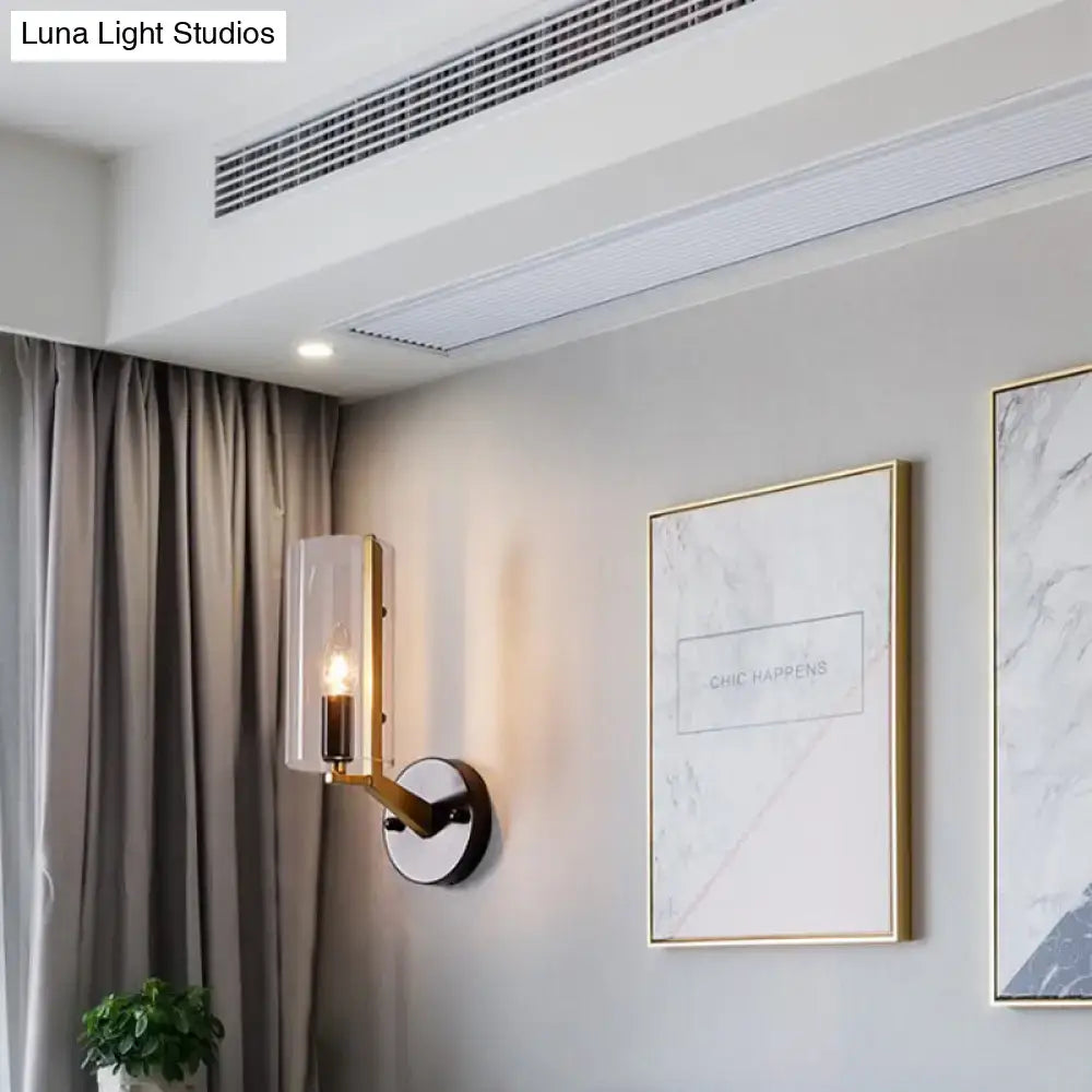 Modern brass-finished wall light with transparent glass sconce and warm-toned bulb for bedroom use