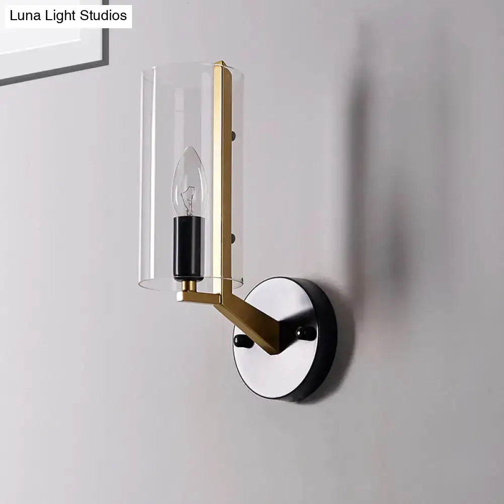 Modern wall light featuring a sleek brass frame, black accents, and a transparent glass sconce for bedroom use